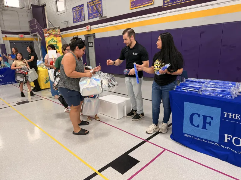 Members of the firm handing out backpacks to families at a New Orleans giveaway