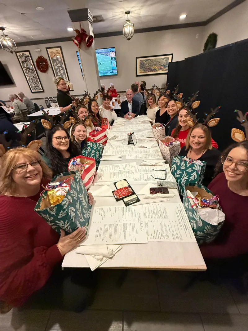 The firm seated along one long table at the holiday dinner